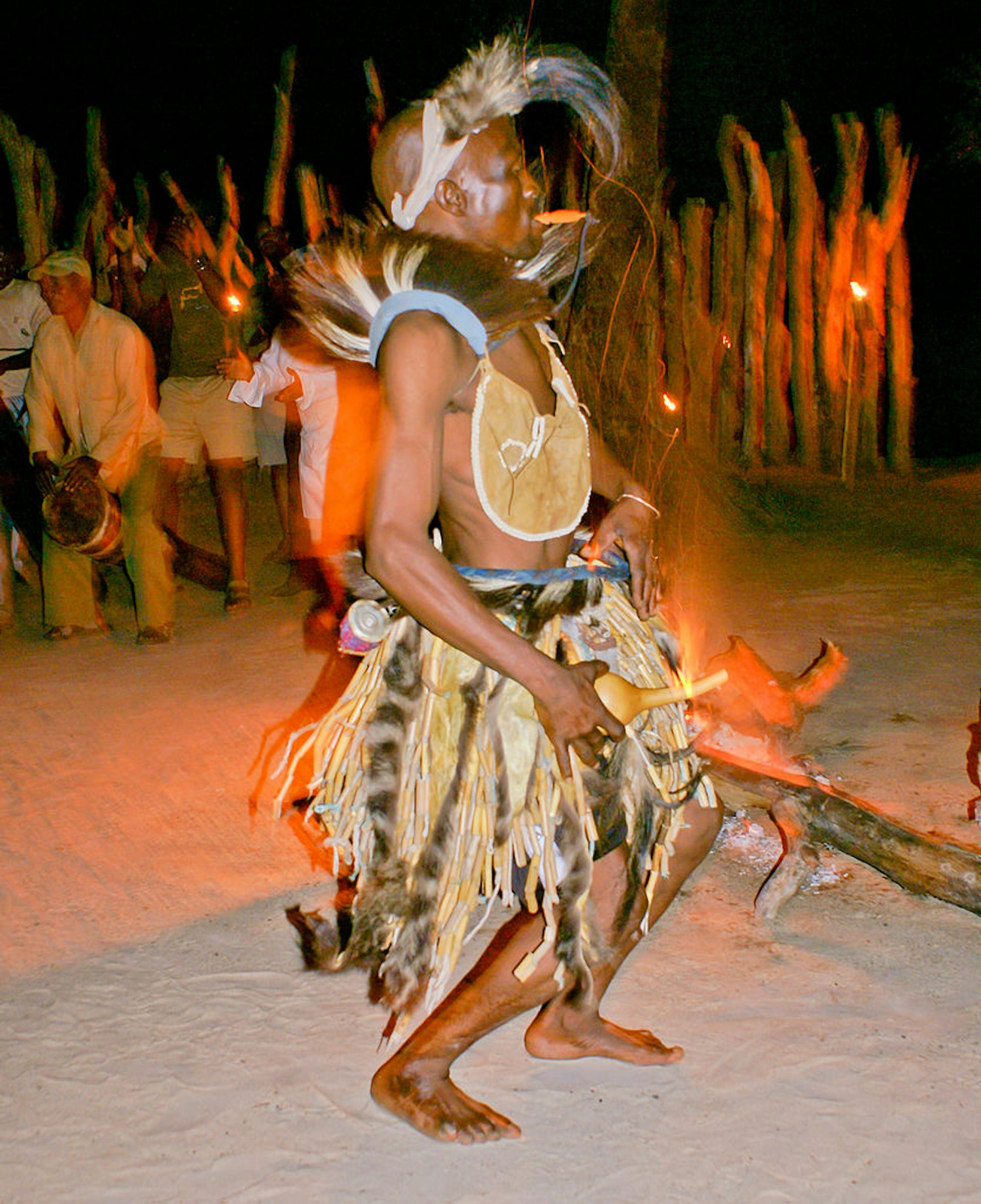 San performing a dance at Camp Jao in Botswana, photographed by Justin Hall, (2007). 